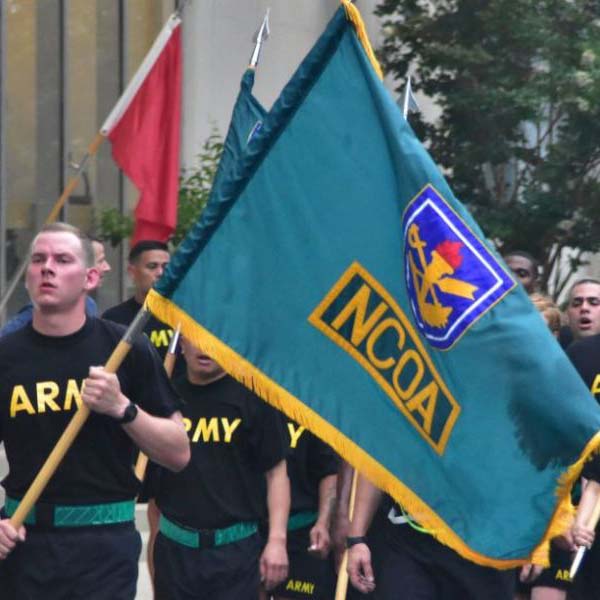 Army students carrying NCOA flags
